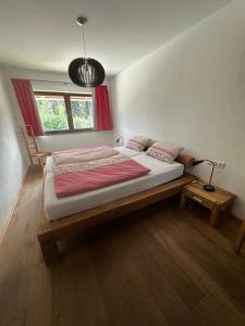 a bedroom with a bed and a window and a lamp at In d'Hütte - Schöne Ferienwohnung und Traumhafte Ferienwohnung in Ravensburg