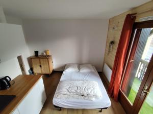une petite chambre avec un lit et une fenêtre dans l'établissement Milky Way - Appartement en bas des pistes du Mourtis, à Boutx