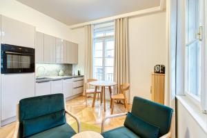 a kitchen and living room with two chairs and a table at AnnaVila in Piešťany