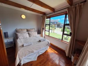 una camera da letto con un letto e una grande finestra di PA Sands Beach House Kowie River 9 Sleeper Pool a Port Alfred Altre 20 foto