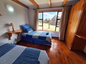 due letti in una stanza con una grande finestra di PA Sands Beach House Kowie River 9 Sleeper Pool a Port Alfred