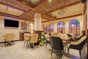 a conference room with tables and chairs and a tv at Hotel O Hazra Inn in Ballygunge