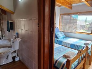 bagno con 2 letti, servizi igienici e finestra di PA Sands Beach House Kowie River 9 Sleeper Pool a Port Alfred