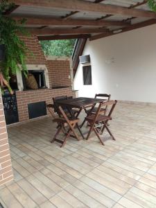 een houten tafel en stoelen op een terras bij Chalé Bem-Estar in Massaranduba