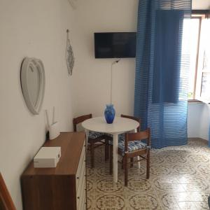a kitchen with a table and chairs and a table and a room at Casa Nenetta in La Maddalena