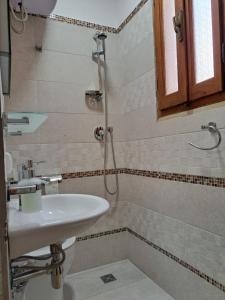 a bathroom with a sink and a shower at Casa Nenetta in La Maddalena +15 photos