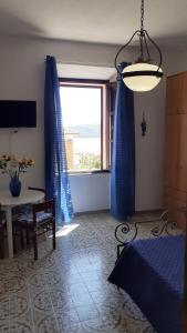 a bedroom with a bed and a window with a table at Casa Nenetta in La Maddalena