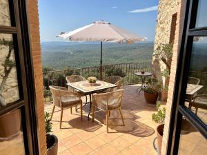a patio with a table and chairs and an umbrella at Mas Maimes in Agullana