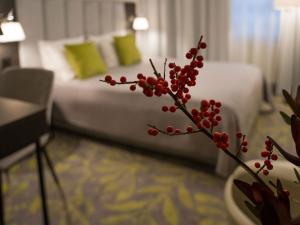 a branch with red berries in a hotel room at Hotel Atrium in Krakow