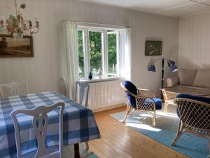 - une chambre avec un lit, des chaises et un canapé dans l'établissement Lilla Halängen cottages, Mormors hus, à Dalskog
