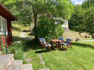 - une table et des chaises dans la cour d'une maison dans l'établissement Lilla Halängen cottages, Mormors hus, à Dalskog