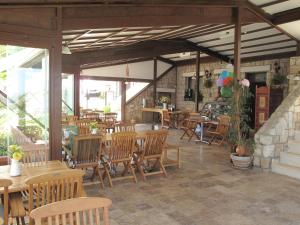 a restaurant with wooden chairs and tables and tables at Nergis Hotel in Karaburun