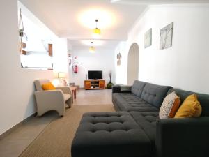 a living room with a couch and a tv at Casa do Cruzeiro in Lagoa