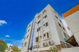 a white building with a blue sky in the background at Super Collection O Besa Square Nagpur Formerly Yuva Inn in Nagpur