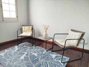 a living room with two chairs and a rug at Casa do Cruzeiro in Lagoa
