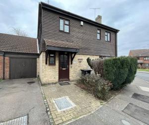 een groot huis met een garage en een oprit bij Brackens House Brentwood in Little Warley
