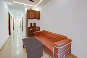 a living room with a brown couch and a table at Hotel O Elite Inn in Dānāpur