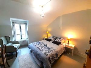a bedroom with a bed and a chair and a window at Belle maison de ville 4 chb cour privee in Châteauroux