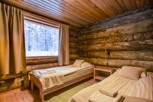 una camera con 2 letti in una baita di tronchi di Oivangin Lomakartano a Kuusamo Altre 108 foto