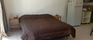 Cama marrón en habitación con nevera en Gran ubicación y servicios, en Buenos Aires