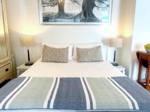 a bedroom with a bed with two lamps on it at Cape Town Explorer's Rest in Meadowridge