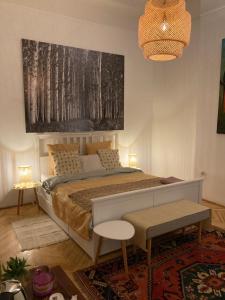 a bedroom with a bed and a large painting on the wall at Chez Marie in Budapest