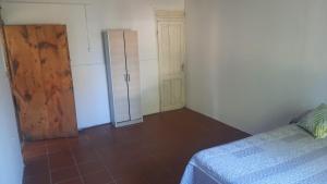 a bedroom with a bed and a wooden door at Amplia en centro de San Gregorio in San Gregorio de Polanco