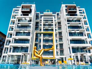 a statue in the water in front of a building at C Central Hotel and Resort The Palm in Dubai