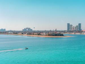 a small boat in the water near a beach at C Central Hotel and Resort The Palm in Dubai