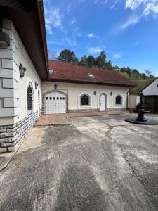 a large white building with a gate and a driveway at Veszprémvölgyi Kúria in Veszprém
