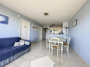 Una sala de estar con un sofá azul y una mesa. en Appartement 1 Chambre + Cabine avec Vue sur Mer & Dunes, 3ème Étage avec Ascenseur - FR-1-236-73, en Stella-Plage