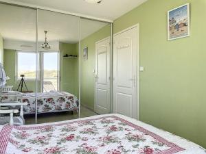 1 dormitorio con espejo, 1 cama y 1 silla en Appartement 1 Chambre + Cabine avec Vue sur Mer & Dunes, 3ème Étage avec Ascenseur - FR-1-236-73, en Stella-Plage 5 fotos más