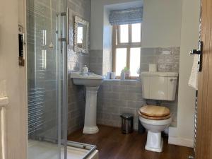 a bathroom with a toilet and a sink and a shower at Hawthorn in Keighley +24 photos