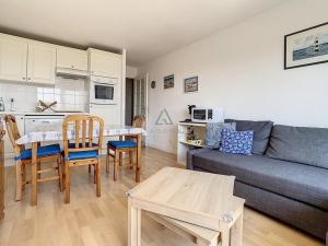 a living room with a couch and a table at Appartement 2 chambres proche mer et centre, parking inclus - FR-1-236-66 in Stella-Plage