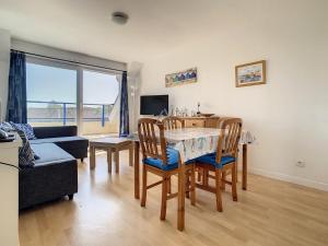 a living room with a table and chairs and a couch at Appartement 2 chambres proche mer et centre, parking inclus - FR-1-236-66 in Stella-Plage