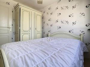 ein Schlafzimmer mit einem weißen Bett und einem weißen Schrank in der Unterkunft Appartement lumineux 2 chambres avec balcon, à 500m de la plage - Centre-ville Stella-Plage - FR-1-236-65 in Cucq + 2 Fotos