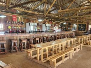 a large wooden bar with wooden tables and stools at The Wool House & Pablo's carolina in Carolina