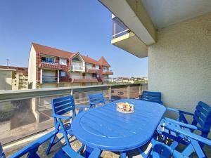 einen blauen Tisch und Stühle auf dem Balkon in der Unterkunft Appartement 3 chambres près de la mer à Stella Plage - FR-1-236-126 in Stella-Plage