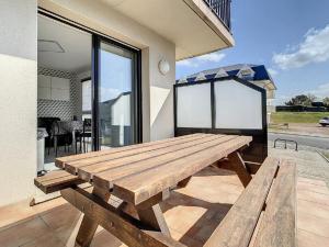 a wooden picnic table on the patio of a house at Charmant T2 à Stella-plage, proche mer, tout confort - FR-1-236-147 in Cucq