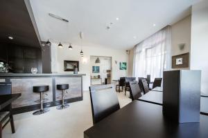 a dining room with tables and chairs and a bar at LOGIS HOTEL - Le Petit Bellon in Senlis