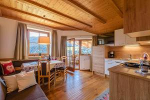 a kitchen and a living room with a table in a room at Familyapartment Alpe - Unterkehrhof in Laion