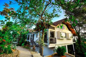 a white house with a tree in front of it at La Vista Resorts in Wayanad