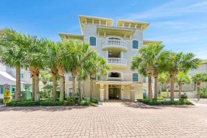 a large building with palm trees in front of it at Penthouse Paradise Condo at Seacrest in Rosemary Beach