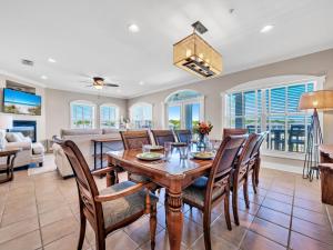 a dining room and living room with a table and chairs at Penthouse Paradise Condo at Seacrest in Rosemary Beach
