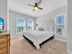a bedroom with a bed with a ceiling fan and windows at Penthouse Paradise Condo at Seacrest in Rosemary Beach +41 photos