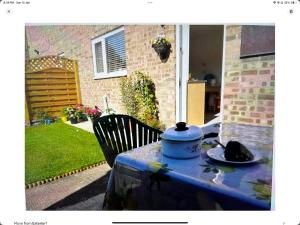 a table with a pot and a cat sitting on it at A lovely double bedroom near GCHQ in Golden Valley