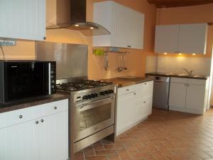 a kitchen with white cabinets and a stove top oven at Gîte Flottille de Loire in Chouzé-sur-Loire