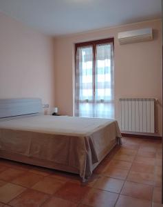 a bedroom with a large bed and a large window at Appartamento Da Vinci in Romentino