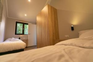 a bedroom with two beds and a window at Pool Lodge - Vakantiepark De Thijmse Berg in Rhenen +59 photos