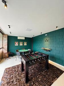a ping pong table in a room with green walls at Bormon Hotel in Nova Veneza
